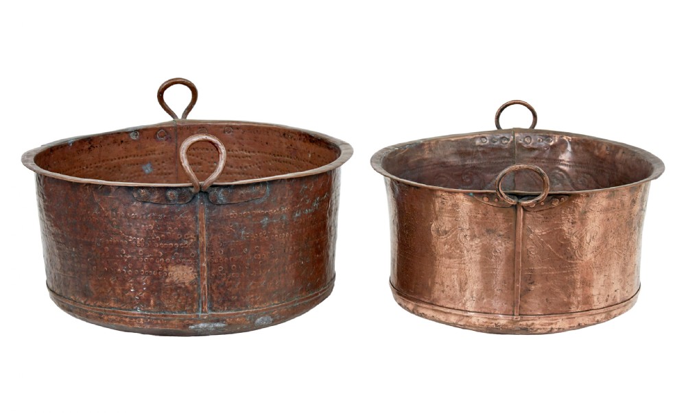 A pair of nineteenth-century hand-hammered copper cooking vessels featuring rolled rims, loop side handles, and chased decorative patterns around the bodies. View II