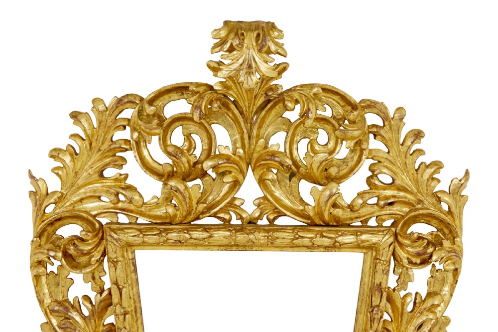 An 18th-century Italian Rococo wall mirror featuring an openwork carved giltwood frame decorated with acanthus leaf scrolls and a decorative cresting around a glass plate. View II