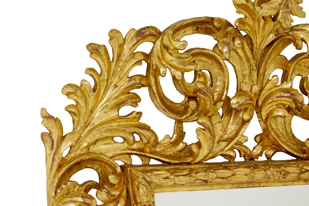 An 18th-century Italian Rococo wall mirror featuring an openwork carved giltwood frame decorated with acanthus leaf scrolls and a decorative cresting around a glass plate. View III