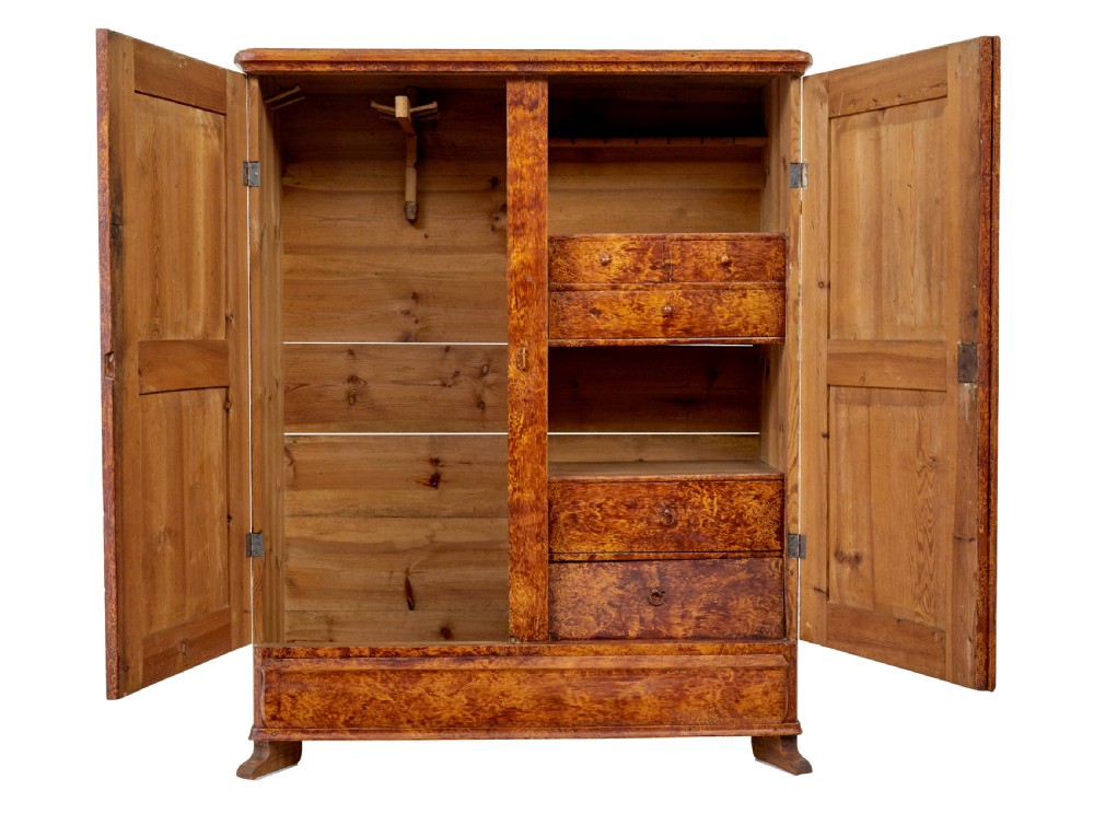 A 19th-century Swedish pine cupboard featuring two panelled doors with a warm amber rag-painted finish and scalloped moulding detailing. View III