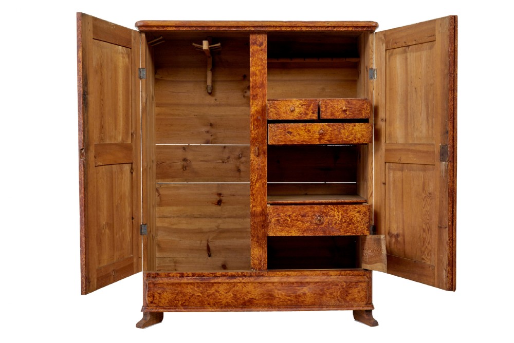 A 19th-century Swedish pine cupboard featuring two panelled doors with a warm amber rag-painted finish and scalloped moulding detailing. View IV