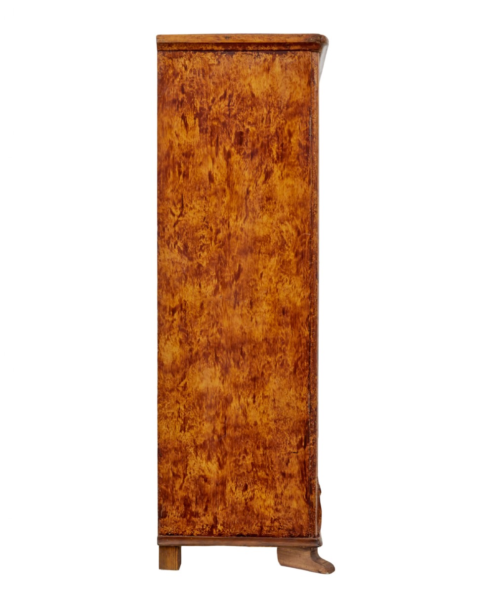 A 19th-century Swedish pine cupboard featuring two panelled doors with a warm amber rag-painted finish and scalloped moulding detailing. View IX