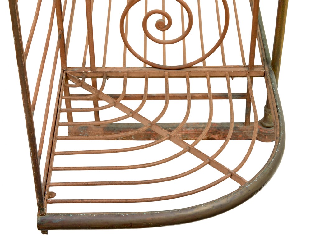 An early 20th-century French wrought iron and brass bakers rack featuring decorative scrollwork and three open slatted shelves. View VII