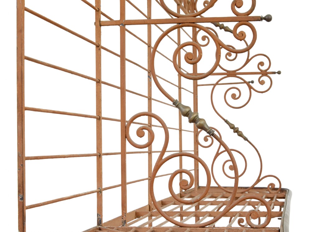 An early 20th-century French wrought iron and brass bakers rack featuring decorative scrollwork and three open slatted shelves. View VIII