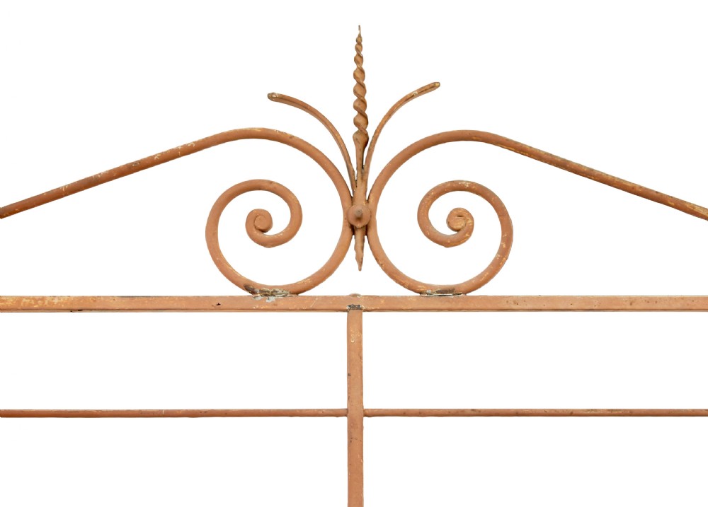 An early 20th-century French wrought iron and brass bakers rack featuring decorative scrollwork and three open slatted shelves. View X