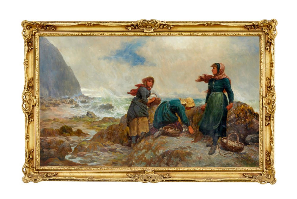 A 19th-century framed oil painting depicting three women gathering shellfish along a rocky, wave-swept coastline set within an ornate gilded frame.