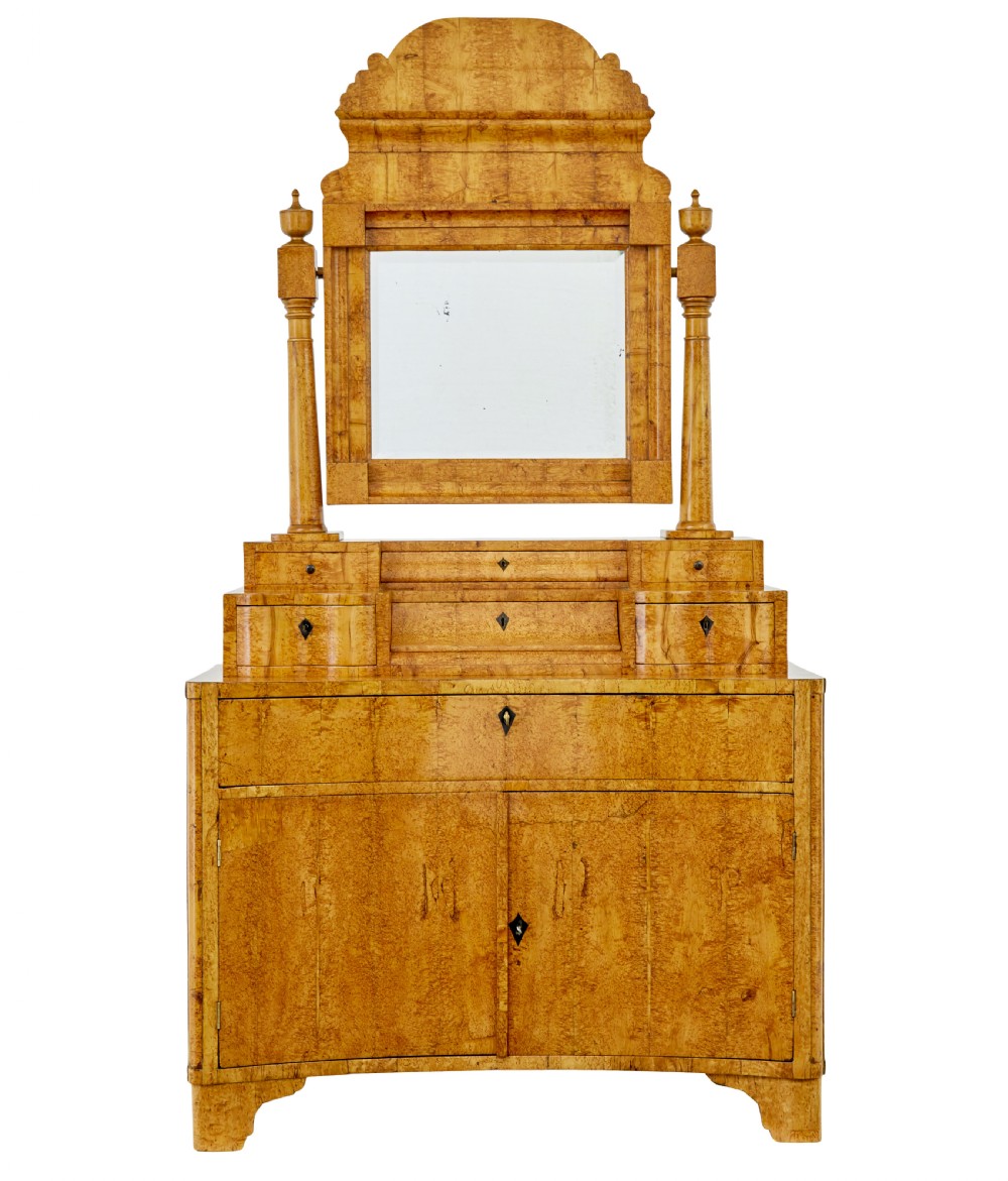 An early 19th-century Biedermeier vanity cabinet featuring a central framed mirror, stepped tier of small drawers, and a double-door base in figured golden birch timber. View II