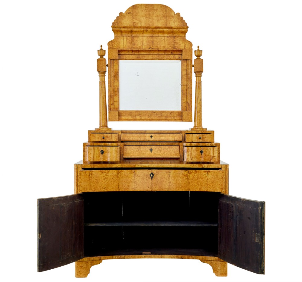 An early 19th-century Biedermeier vanity cabinet featuring a central framed mirror, stepped tier of small drawers, and a double-door base in figured golden birch timber. View III