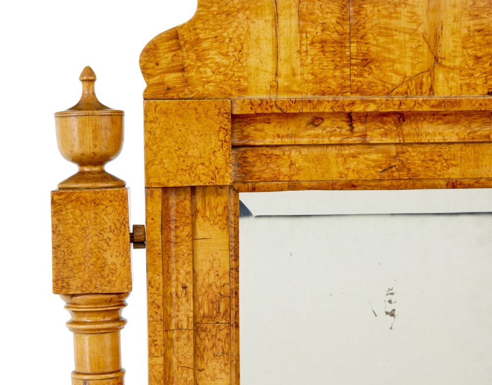 An early 19th-century Biedermeier vanity cabinet featuring a central framed mirror, stepped tier of small drawers, and a double-door base in figured golden birch timber. View X