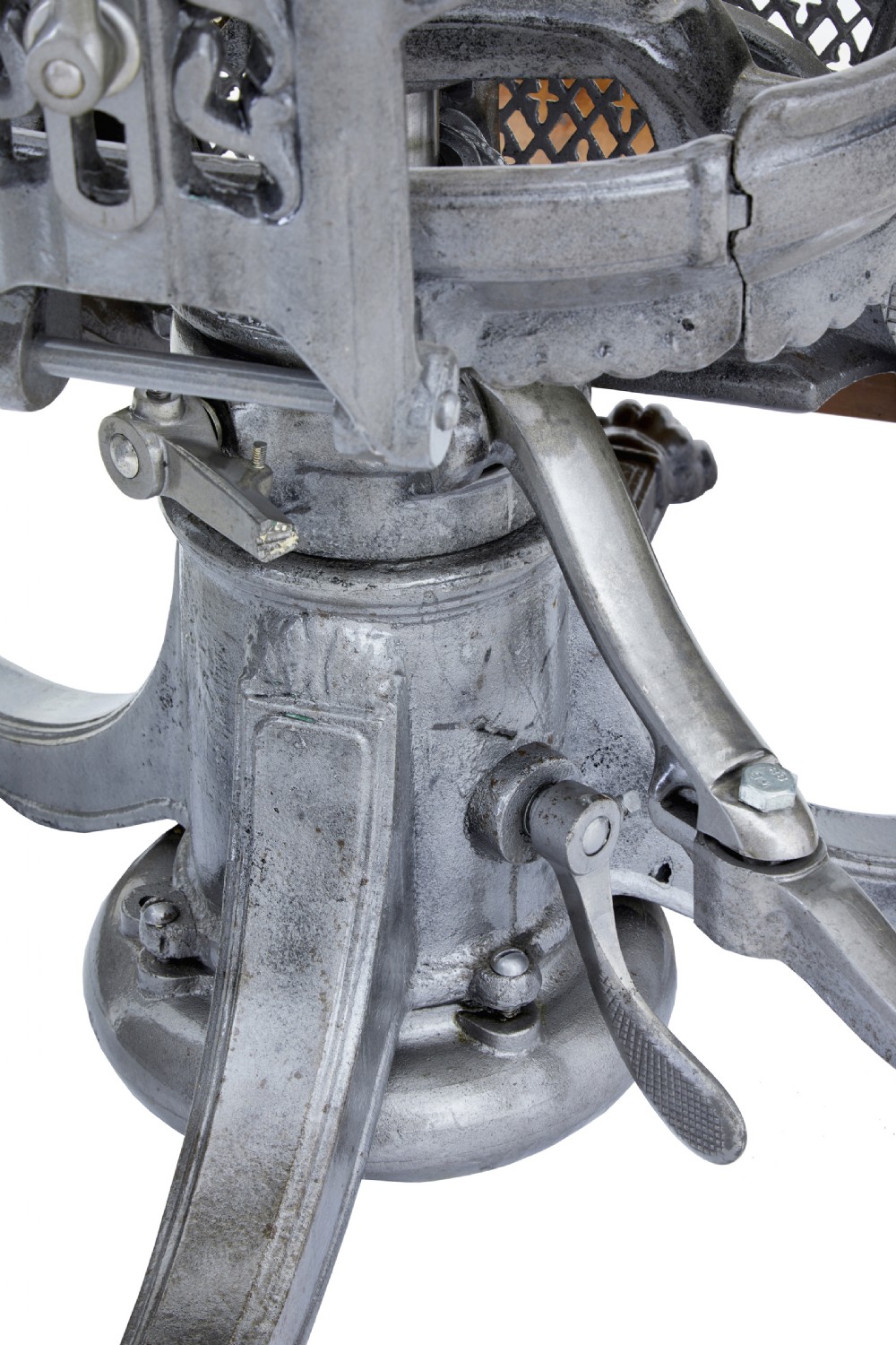 A 19th-century American cast iron dentist chair featuring an adjustable headrest, cream upholstered seat, wooden armrests, and footrest supported by clawed iron feet. View VI