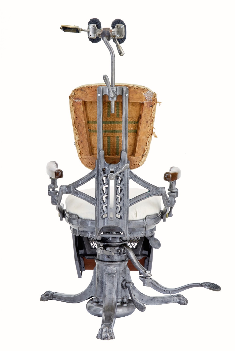 A 19th-century American cast iron dentist chair featuring an adjustable headrest, cream upholstered seat, wooden armrests, and footrest supported by clawed iron feet. View X