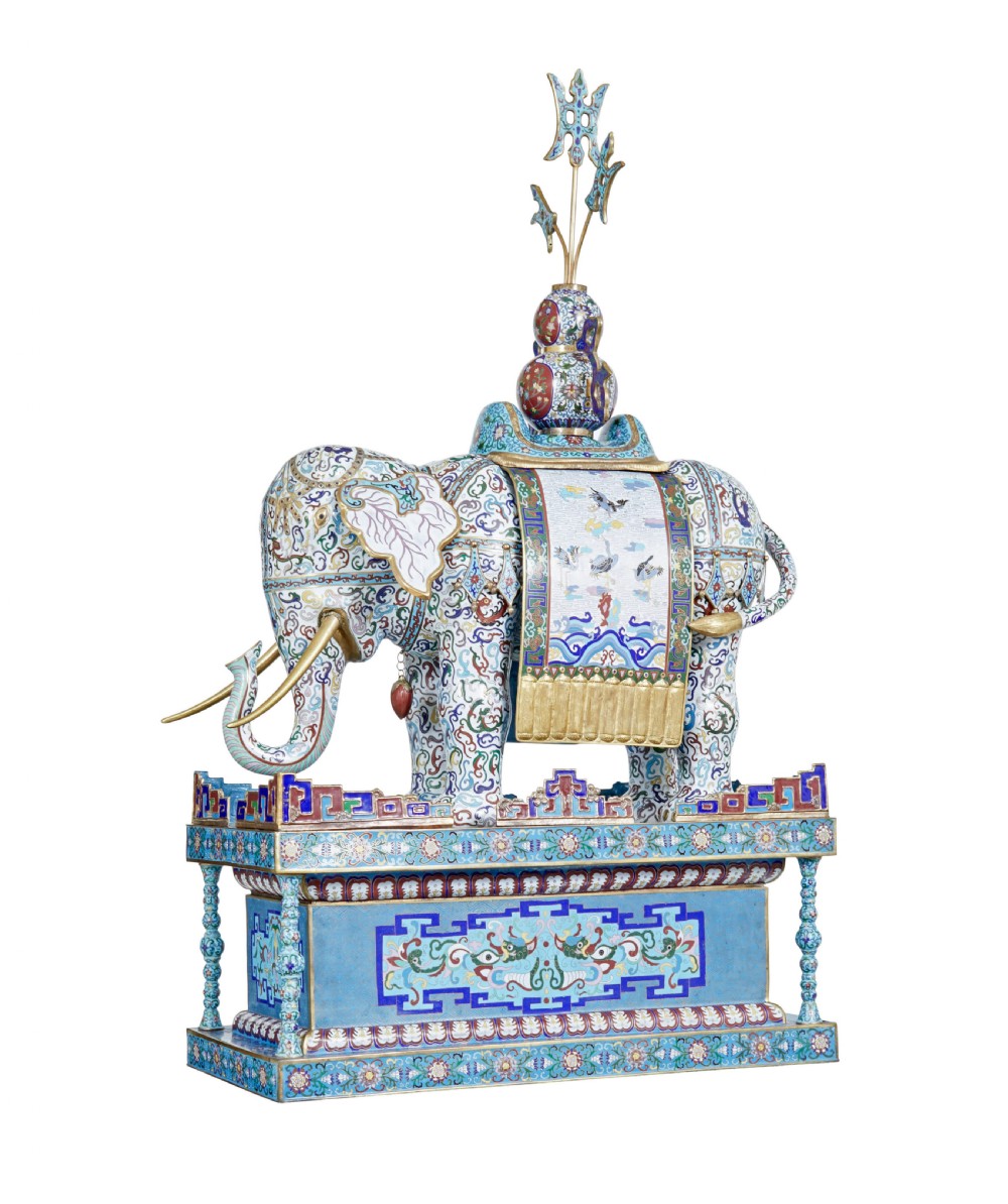 An ornate Chinese cloisonne enamel elephant sculpture with a decorated saddle blanket, standing atop a matching enamel pedestal base. View II