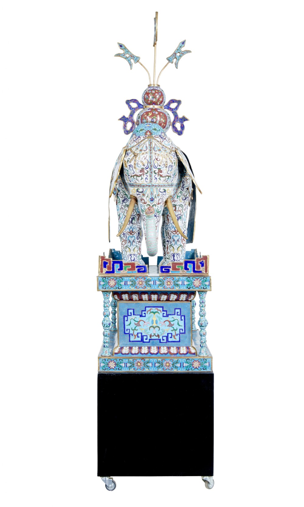 An ornate Chinese cloisonne enamel elephant sculpture with a decorated saddle blanket, standing atop a matching enamel pedestal base. View VI