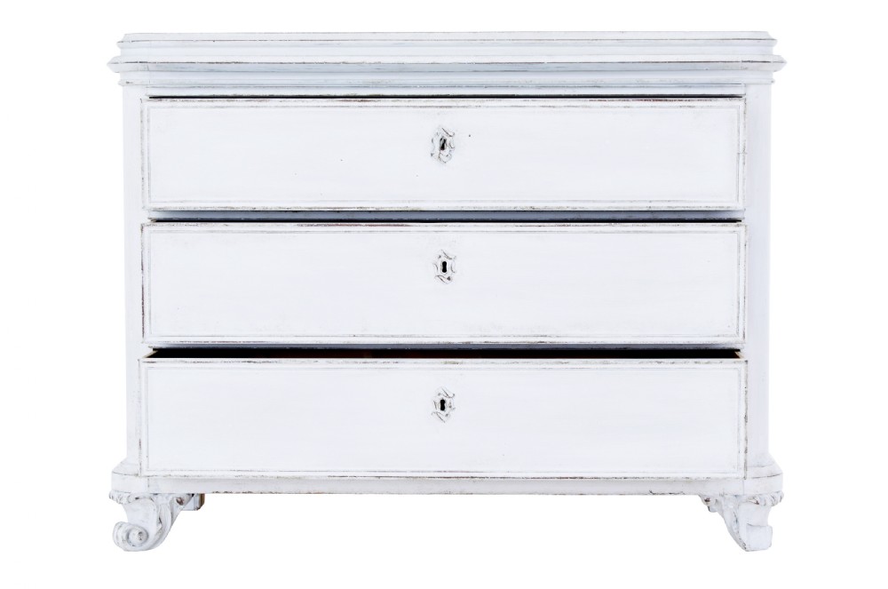 A 19th-century Swedish chest of drawers featuring three long drawers with central escutcheons and a distressed white painted finish resting on carved feet. View III