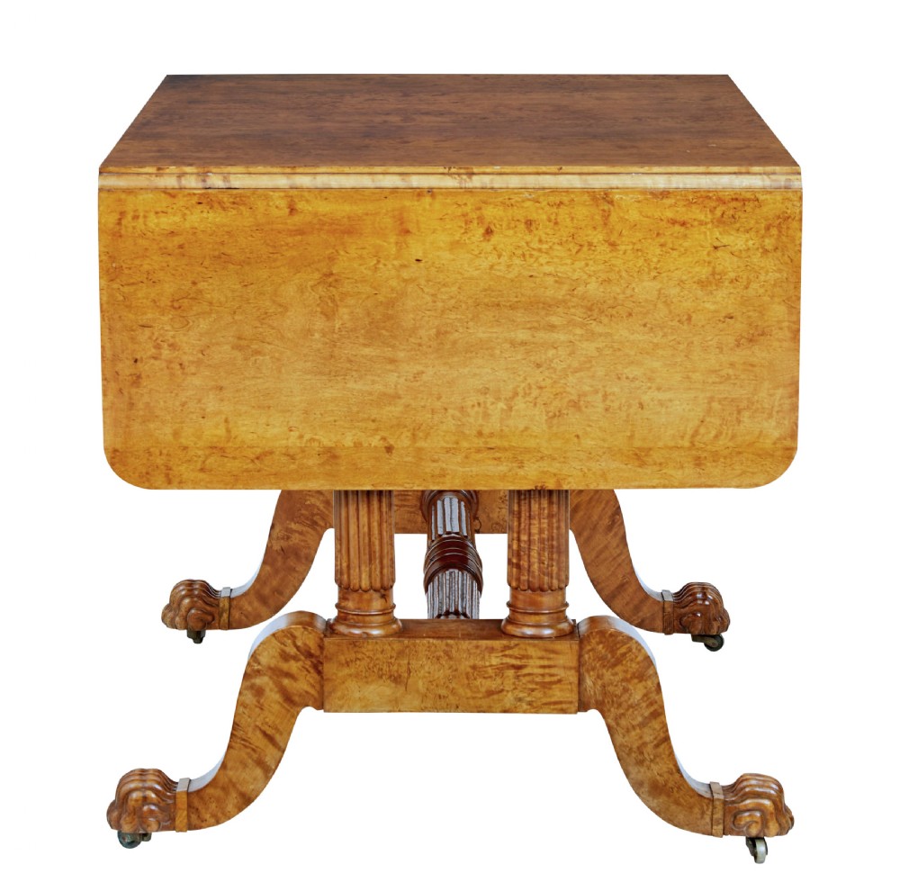 A nineteenth-century Biedermeier burr birch sofa table featuring twin drop leaves, a frieze drawer, fluted column supports, a turned central stretcher, and carved paw feet on castors. View VII