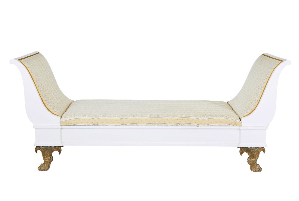 An early 20th-century Scandinavian Empire Revival day bed featuring a white painted frame, flared scroll ends, carved gilded paw feet, and yellow striped fabric upholstery. View II