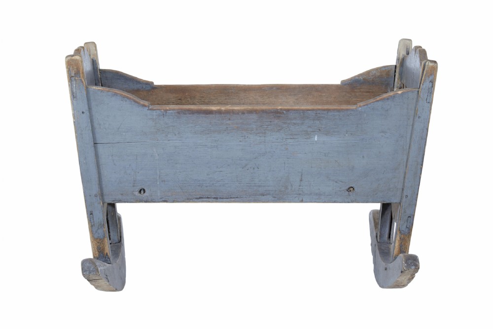 A mid 19th century Swedish pine rocking cradle featuring distressed blue paint and carved wooden ends mounted on twin rockers. View IV