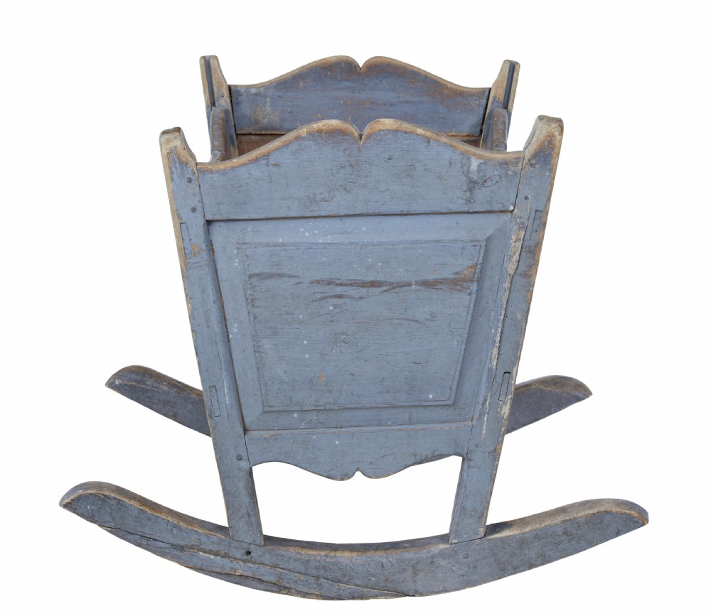A mid 19th century Swedish pine rocking cradle featuring distressed blue paint and carved wooden ends mounted on twin rockers. View V