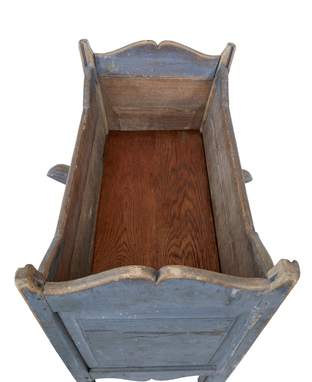 A mid 19th century Swedish pine rocking cradle featuring distressed blue paint and carved wooden ends mounted on twin rockers. View VI
