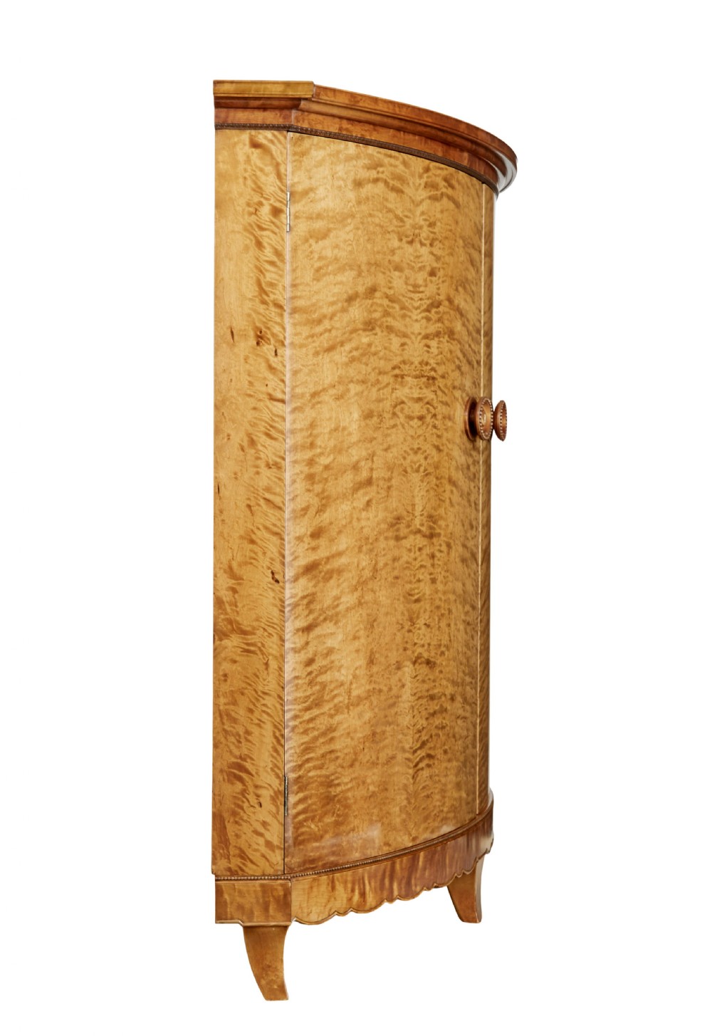A large curved cabinet crafted from honey-coloured flame birch with four panelled doors, circular beaded keyholes, and a scalloped lower trim. View V