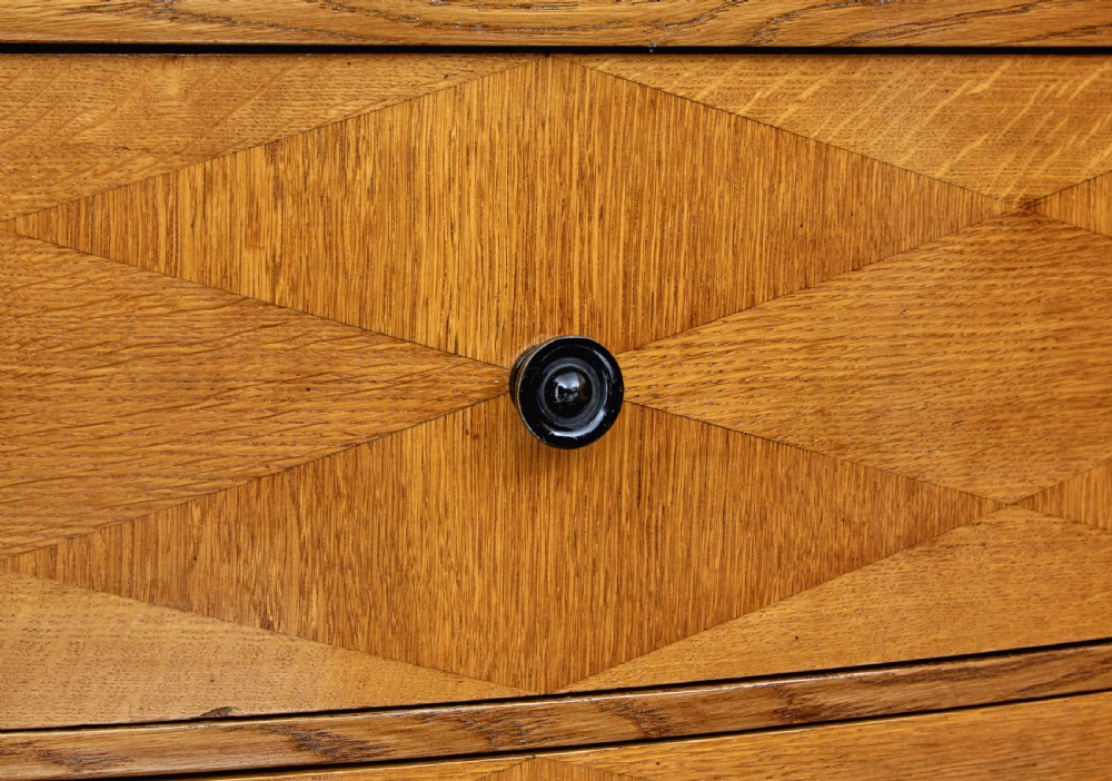 A large curved cabinet crafted from honey-coloured flame birch with four panelled doors, circular beaded keyholes, and a scalloped lower trim. View XII