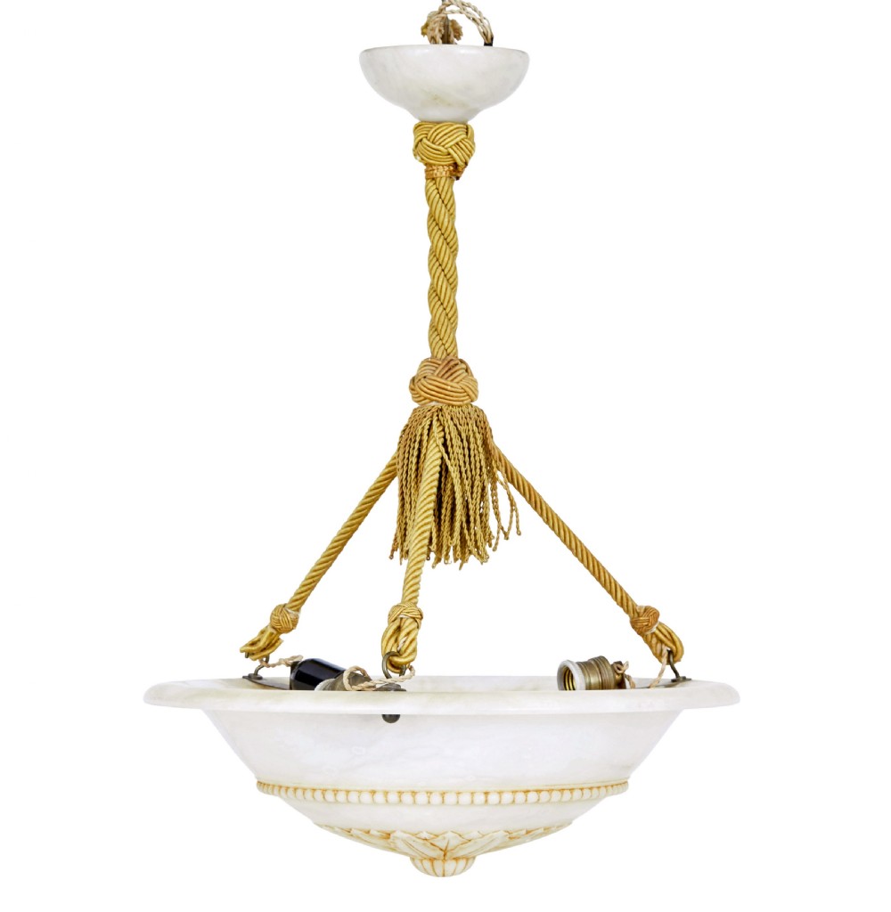 An Art Deco carved alabaster bowl pendant light suspended by braided gold ropes with decorative tassels.