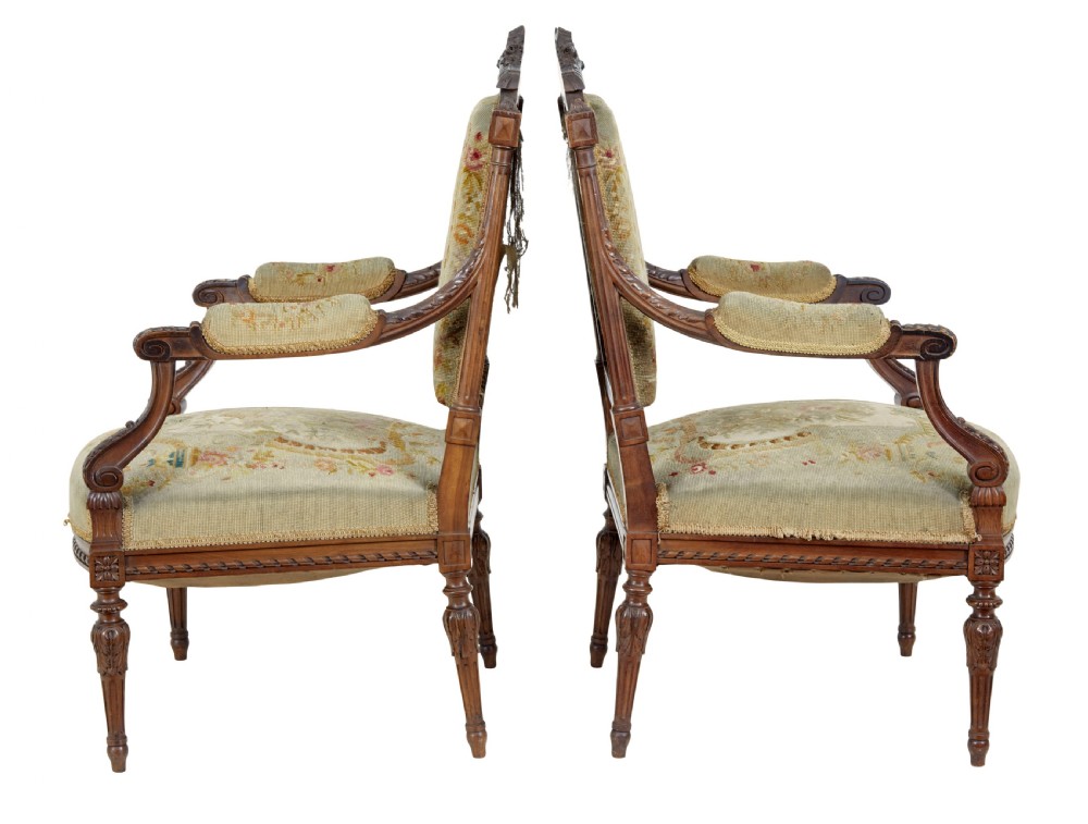 A pair of 19th-century French carved walnut armchairs upholstered in woven tapestry fabric featuring pastoral scenes and fluted turned legs. View II