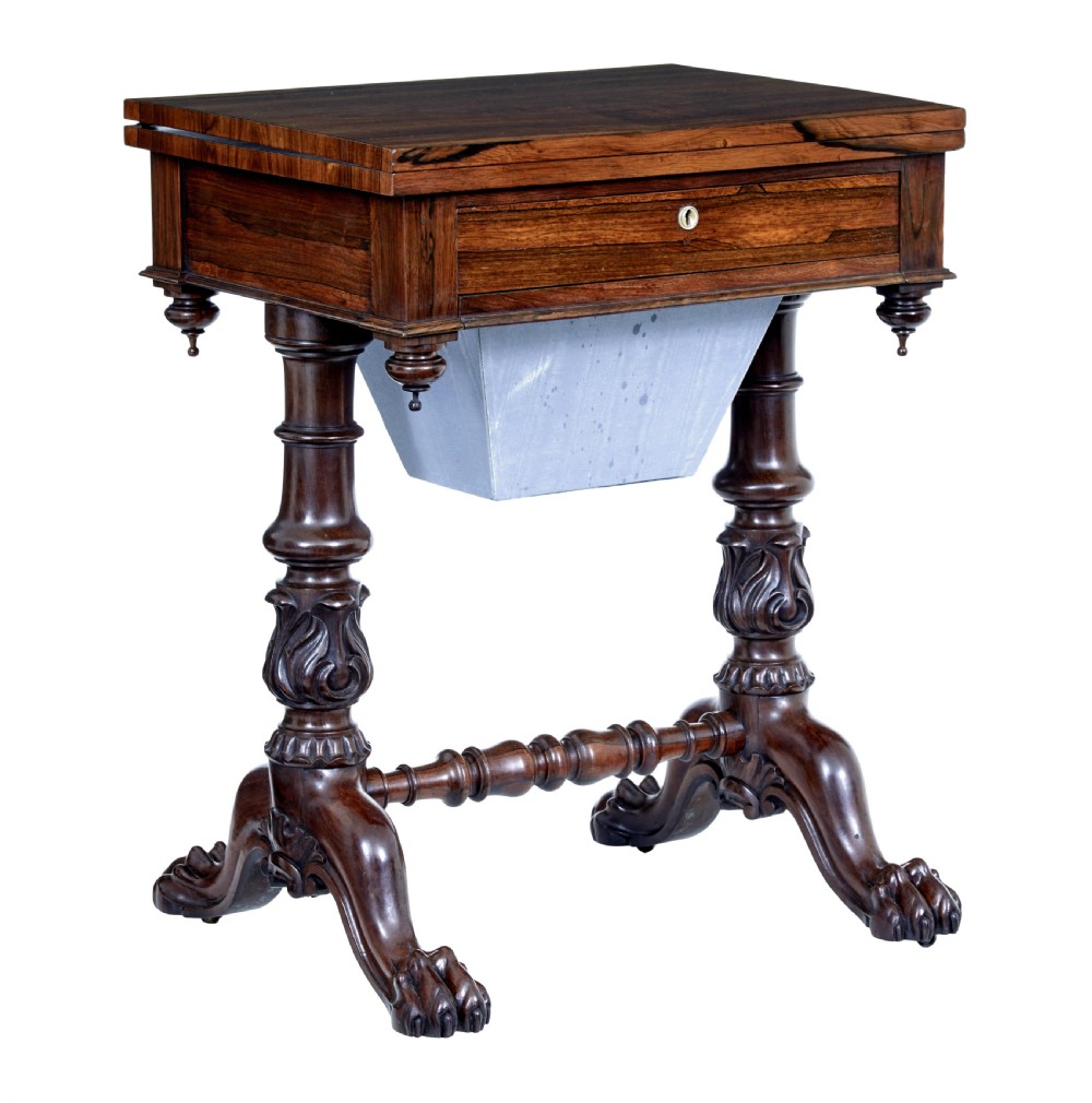A 19th-century William IV palisander flip-top side table featuring carved legs, claw feet, a single drawer, and a suspended work well beneath.