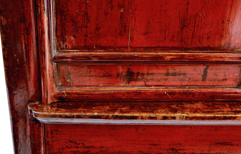 A tall 19th-century Chinese red lacquer cupboard with two panelled doors, metal lockplates, and a shaped lower apron. View VII