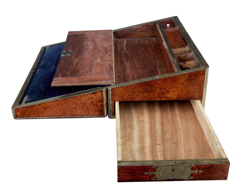 A closed mid-19th-century burr walnut campaign lap writing desk with flush brass corner brackets and brass strapping. View II