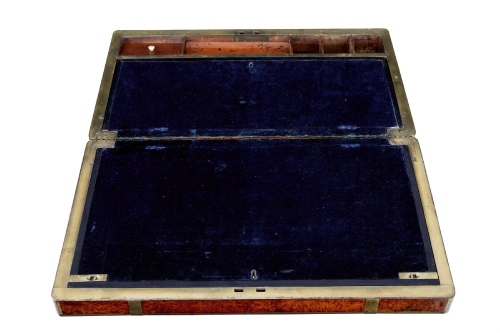 A closed mid-19th-century burr walnut campaign lap writing desk with flush brass corner brackets and brass strapping. View III