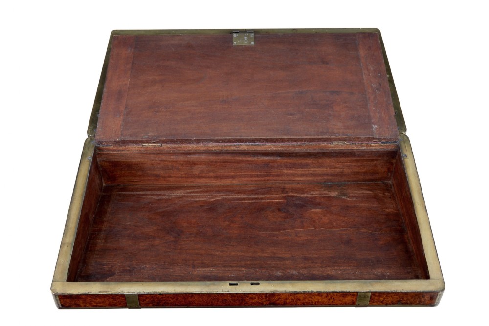 A closed mid-19th-century burr walnut campaign lap writing desk with flush brass corner brackets and brass strapping. View IV