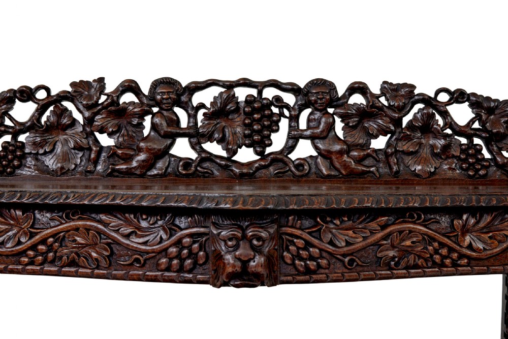 A 19th-century dark oak Victorian buffet featuring three tiers, intricate grapevine relief carvings, turned support columns, and a lower double-door cupboard. View II