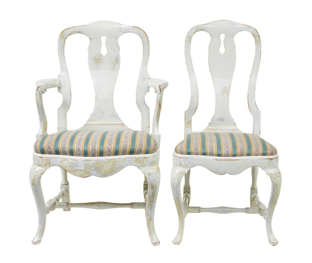 A set of fourteen distressed off-white lacquered Queen Anne style dining chairs featuring vasiform splats, cabriole legs, and striped textile upholstery. View III