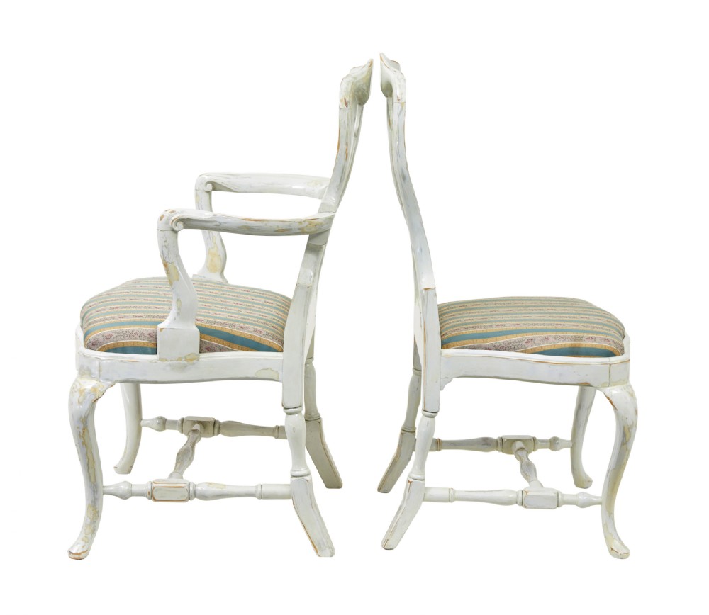 A set of fourteen distressed off-white lacquered Queen Anne style dining chairs featuring vasiform splats, cabriole legs, and striped textile upholstery. View IV