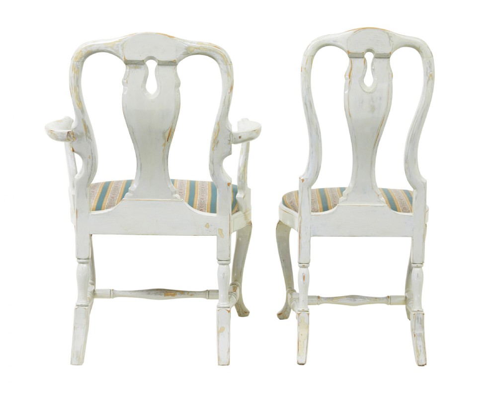 A set of fourteen distressed off-white lacquered Queen Anne style dining chairs featuring vasiform splats, cabriole legs, and striped textile upholstery. View VI