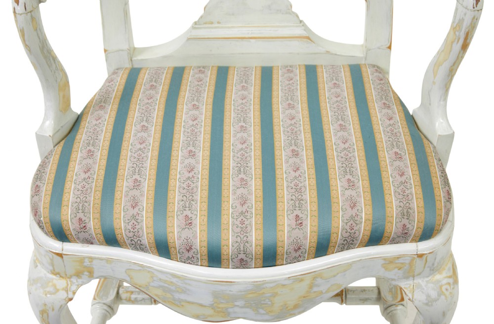 A set of fourteen distressed off-white lacquered Queen Anne style dining chairs featuring vasiform splats, cabriole legs, and striped textile upholstery. View VIII