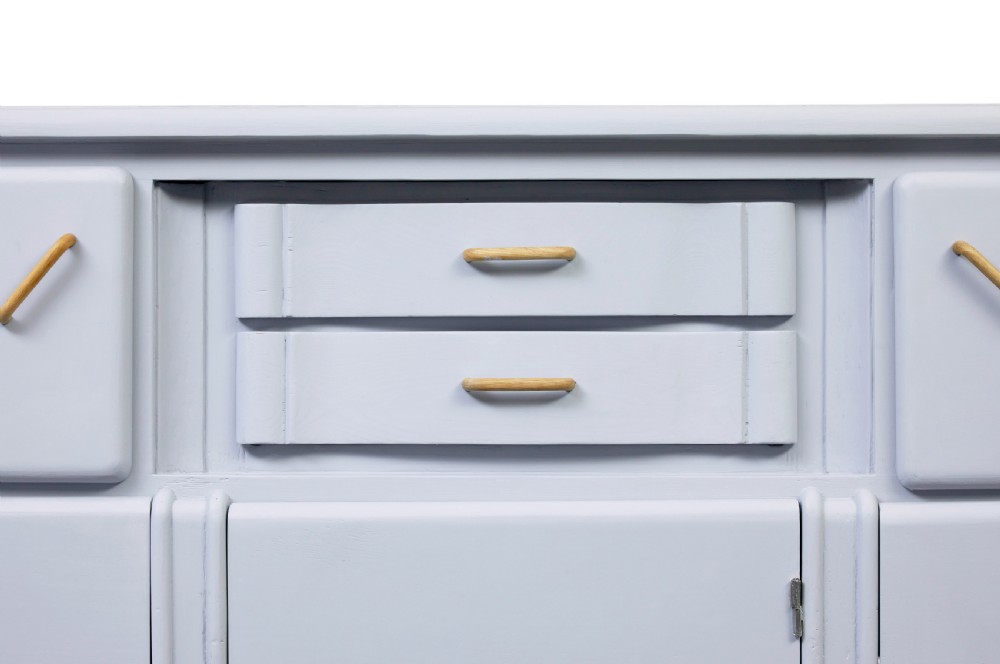 A pale blue-grey painted pine kitchen sideboard featuring five panelled cupboard doors and two central stacked drawers. View V