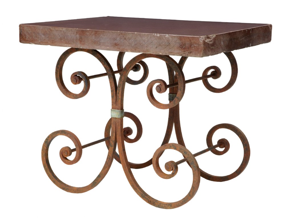 A 1920s French baker table with a thick red marble slab top resting on a scrollwork wrought iron frame.