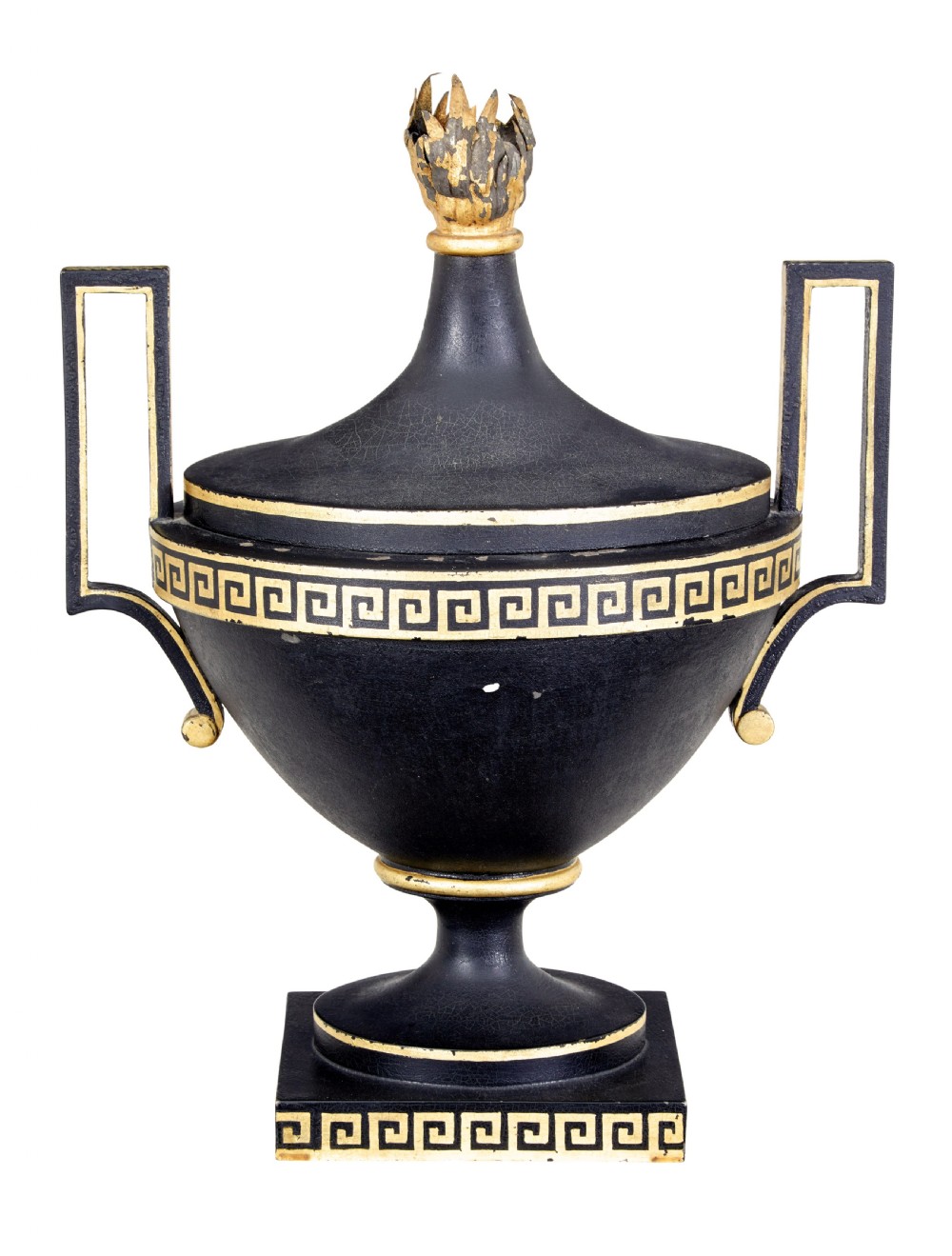 An early 19th-century black painted metal toleware urn with gilded Greek key decoration, angular handles, and a flame finial on a square plinth.