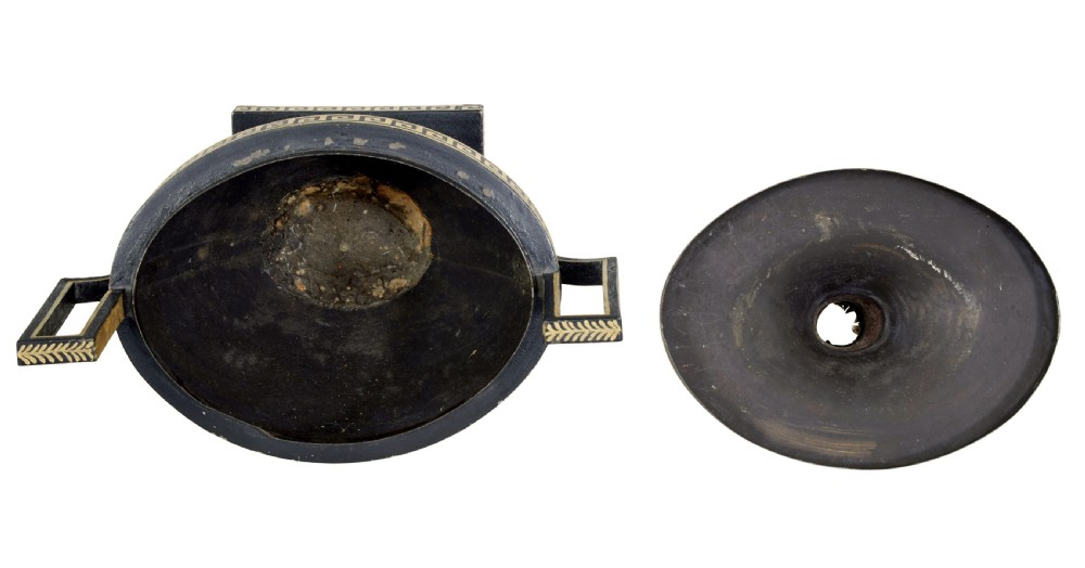 An early 19th-century black painted metal toleware urn with gilded Greek key decoration, angular handles, and a flame finial on a square plinth. View VI
