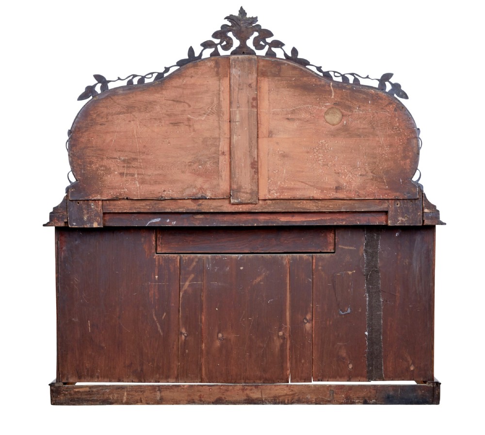 A Victorian flame mahogany sideboard featuring a carved botanical frame around an oval mirror top above cupboard doors and pedestal bases. View VII