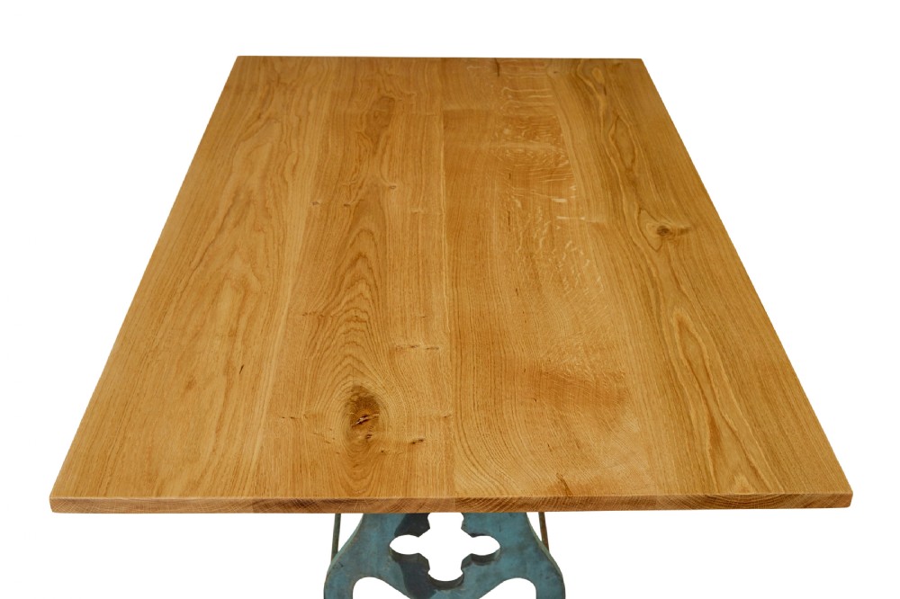 An industrial table featuring a rectangular natural oak top supported by a blue painted cast iron machine base on castors. View VI
