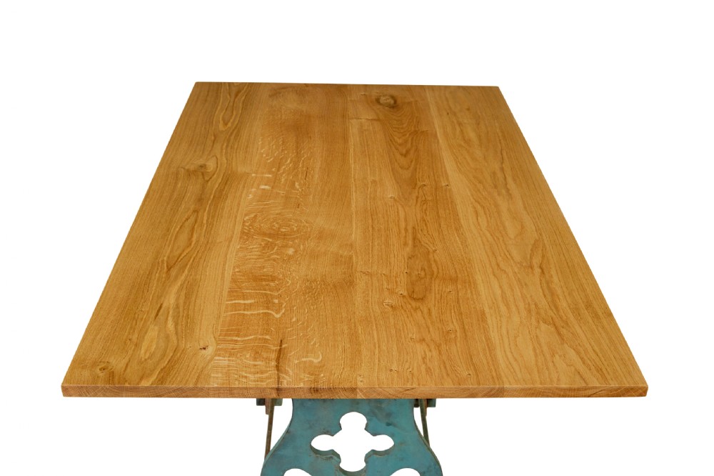 An industrial table featuring a rectangular natural oak top supported by a blue painted cast iron machine base on castors. View VII
