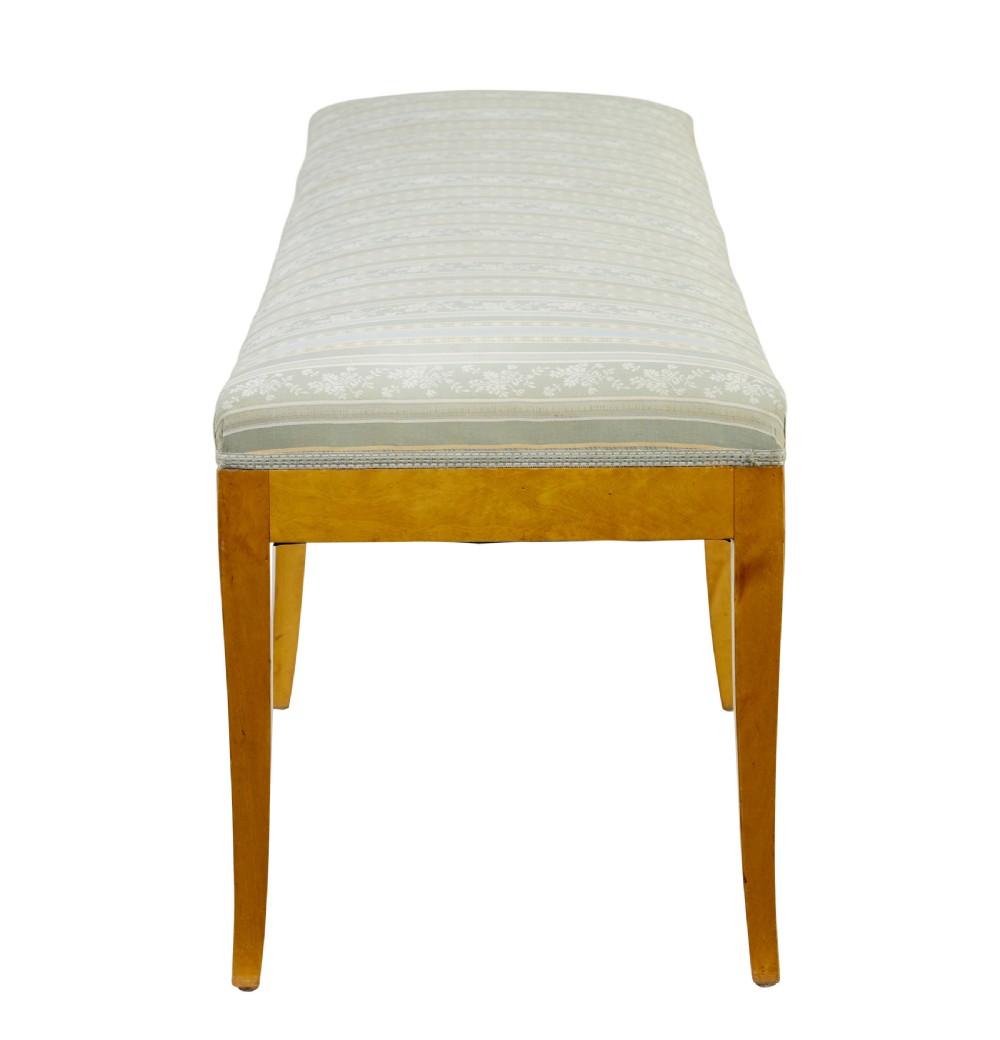 An early 20th-century Swedish long stool made of light honey-coloured birch wood with six square tapered legs and light blue striped upholstered seat. View III