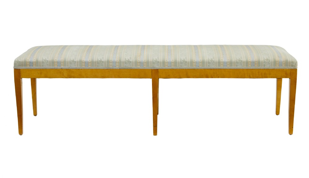 An early 20th-century Swedish long stool made of light honey-coloured birch wood with six square tapered legs and light blue striped upholstered seat. View IV