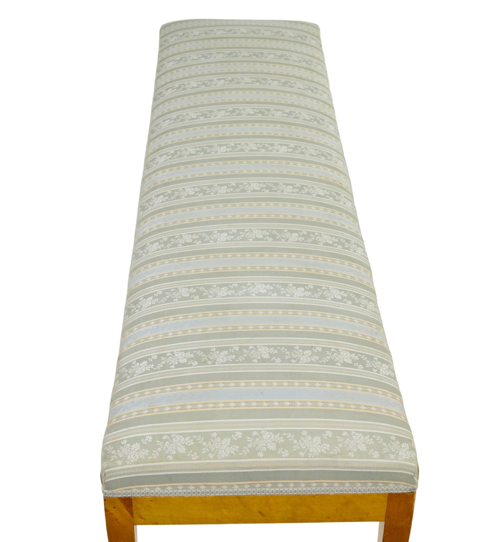An early 20th-century Swedish long stool made of light honey-coloured birch wood with six square tapered legs and light blue striped upholstered seat. View VI