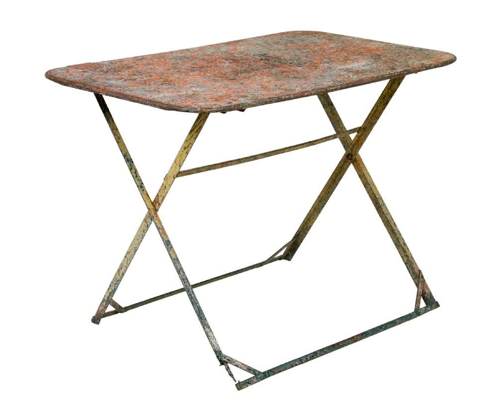 A rectangular folding metal garden table featuring a heavily distressed, multi-coloured painted surface and an X-frame iron base.