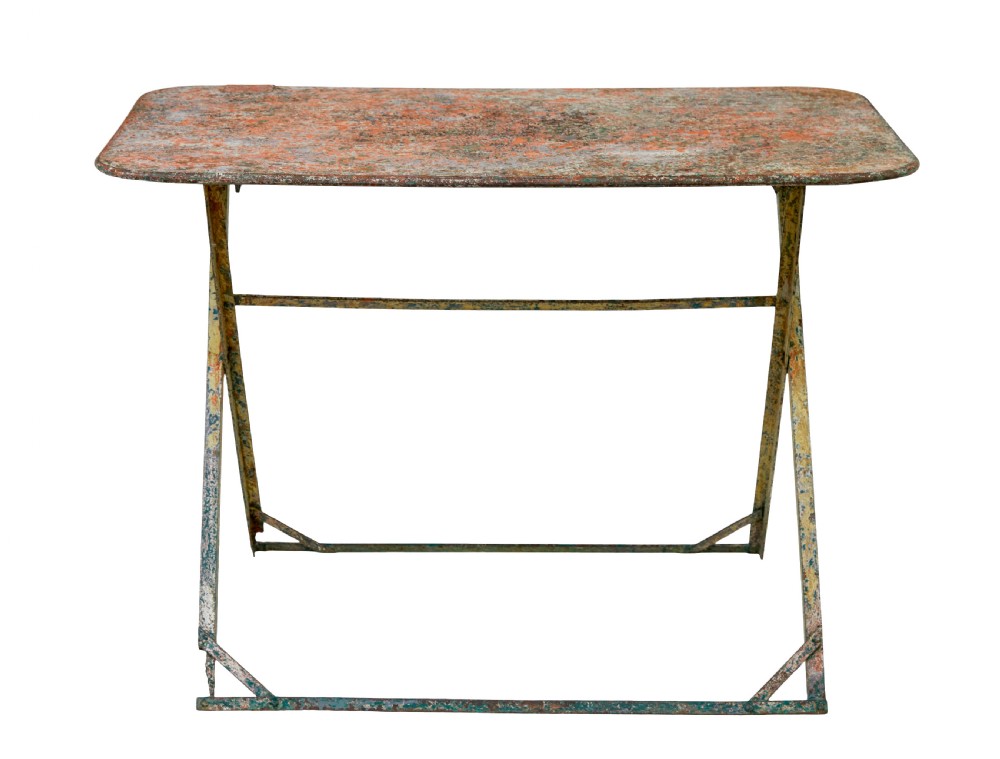 A rectangular folding metal garden table featuring a heavily distressed, multi-coloured painted surface and an X-frame iron base. View VIII