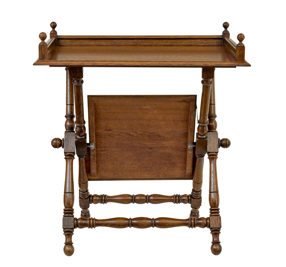 A 19th-century oak butlers tray table featuring a gallery-edged top tray with corner finials, a lower tiered shelf, and turned X-frame folding legs. View III